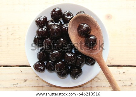 Amarena Cherries on a white plate with a wooden spoon Royalty-Free Stock Photo #646210516