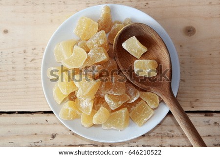 Dried ginger on a white plate with a wooden spoon Royalty-Free Stock Photo #646210522