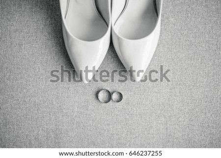 Wedding details, bride shoes, rings. White lacquered shoes with heels.