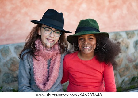 Two happy girls friends with stylish hats lauging 