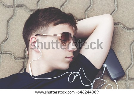 Stylish teenager in headphones listening to music