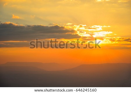 View of sunset (twilight sky) with clouds on mountain in the wild, Silhouette picture, gold light sky.
