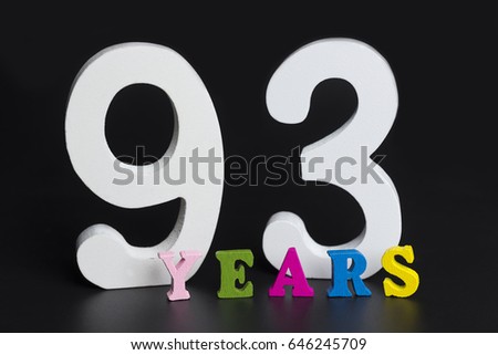 Letters and numbers ninety-three years on black isolated background.