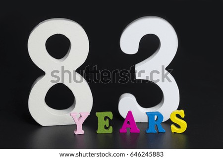 Letters and numbers eighty-three years on black isolated background.