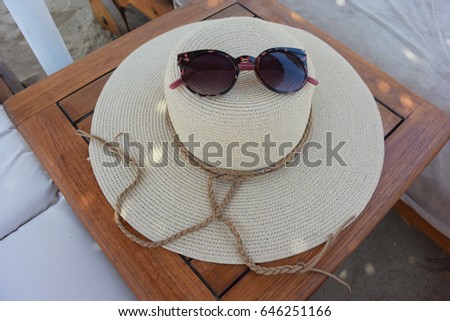 close up of hat and sunglasses at the beach