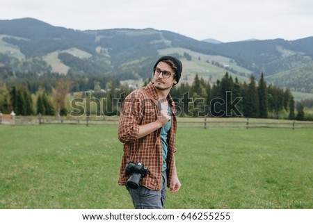 Man with camera in the mountains. Photographer. Tourist.