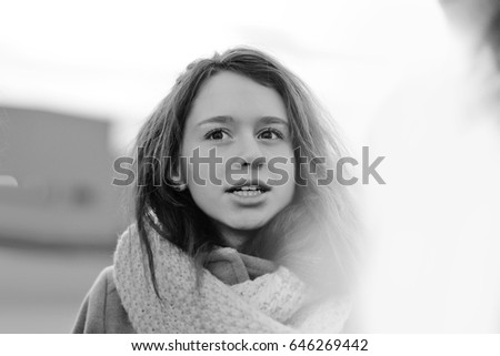 young girl with scarf walking in cold weather/ Back and white photo