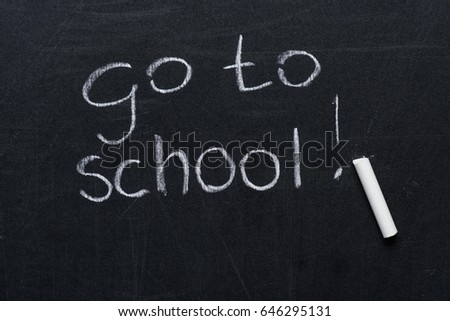 phrase go to school with exclamation mark and piece of chalk on blackboard