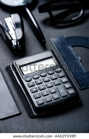 calculator with various office utensils mock-up isolated on black