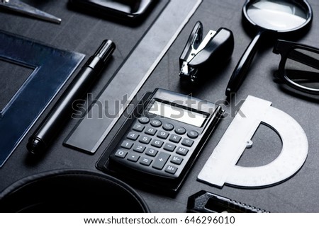 calculator with various office utensils mock-up isolated on black