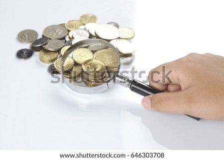 Close-up Of  Coins With Magnifier On Desk