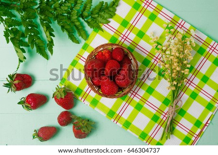 strawberries and green leaves on a green table