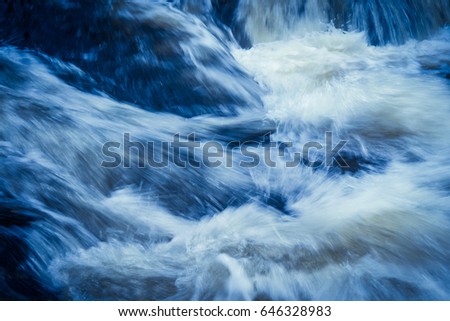 Powerful currents of river water converge in violent splashes.