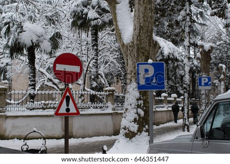 Elements road signs warning and Parking place for information in a snowy city