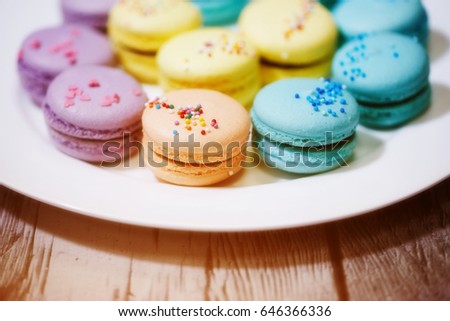 Tasty french macarons on a wooden table with vintage color tone, Macarons is a French sweet meringue-based