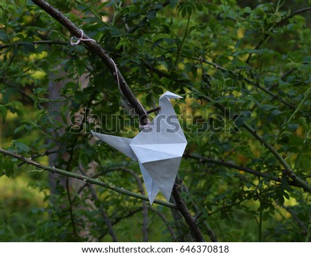 Paper figures origami bird on the tree
