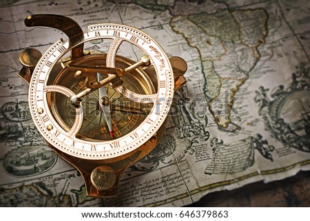 Close-up view of a vintage compass on an old retro map. The map used for background is in Public domain. Map source: New York Public Library Royalty-Free Stock Photo #646379863