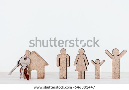 Wooden family shape and home on wooden table