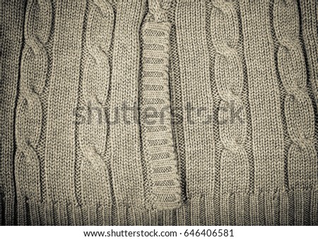 Knitted pattern from woolen warm soft yarn for background. Toned.