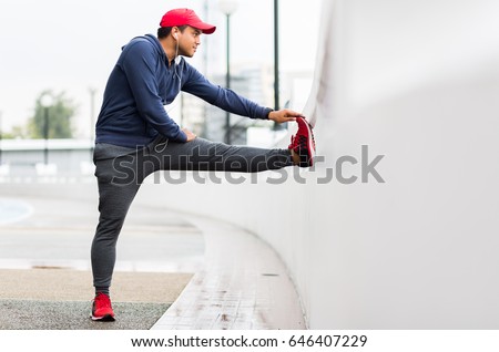Portrait of handsome young man stretching legs before exercise run outdoors. Royalty-Free Stock Photo #646407229