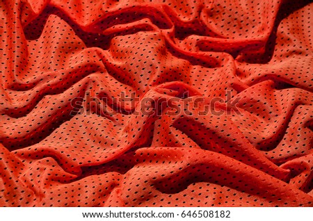 Red sport clothing fabric texture background. Top view of red cloth textile surface. Bright basketball shirt. Text Space