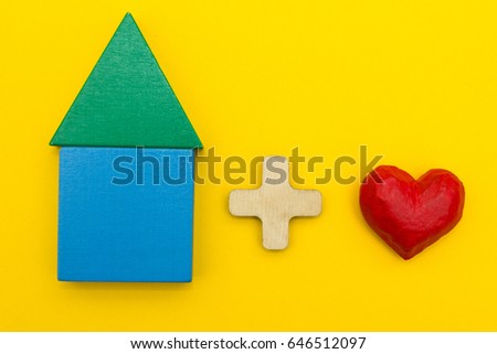 Figurine of the house plus heart on a yellow background