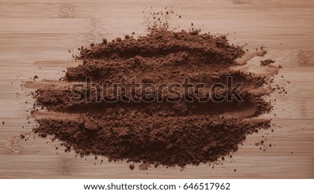 pile cocoa powder on wooden table