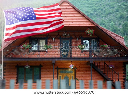 Waving USA flag in front of house