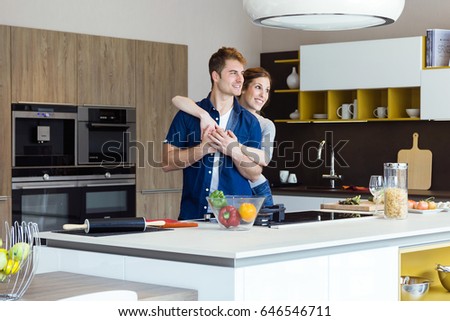 Portrait of beautiful young couple having fun in the kitchen at home.