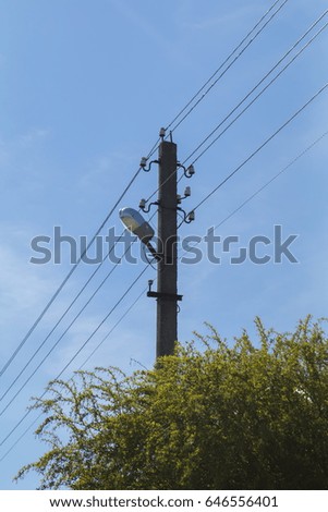 Pole with electric wires against the blue sky