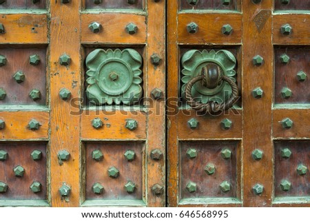 Wooden antique door with copper patterned handles
