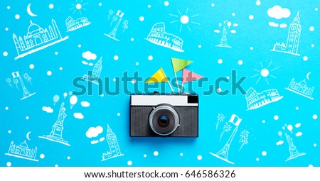 photo of retro camera and colorful flags on the wonderful blue studio background