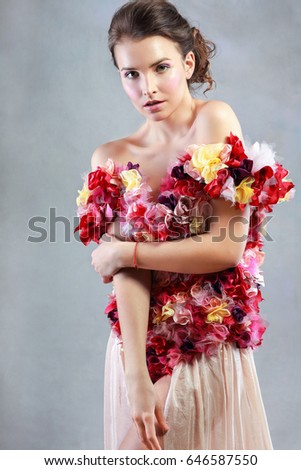 half length portrait of young beautiful woman wearing dress with flowers standing next to color background