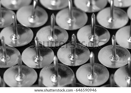Thumb tacks (drawing pins) on a dark background close up. Background