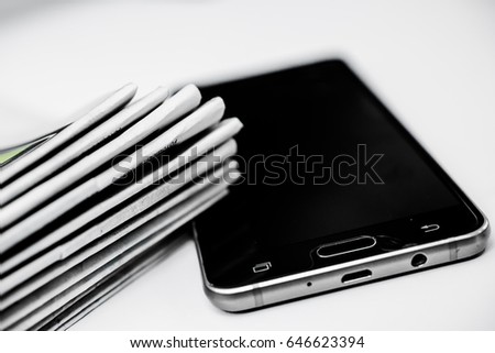 Cell phone and stack of newspapers