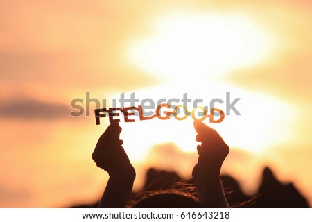 FEEL GOOD text in hands on the sunset sky Royalty-Free Stock Photo #646643218
