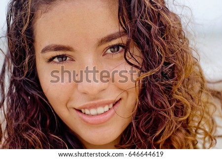 Close up face shot of a young mexican woman looking at the camera.