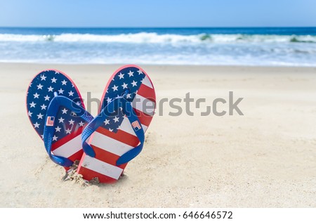 Patriotic USA background with flip flops and decorations on the sandy beach