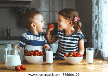 Happy children girl and boy brother and sister eating strawberries with milk
 Royalty-Free Stock Photo #646666123