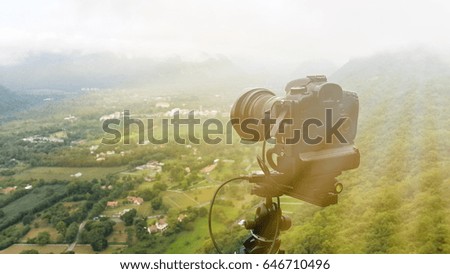 Photo camera mounted on tripod outdoors