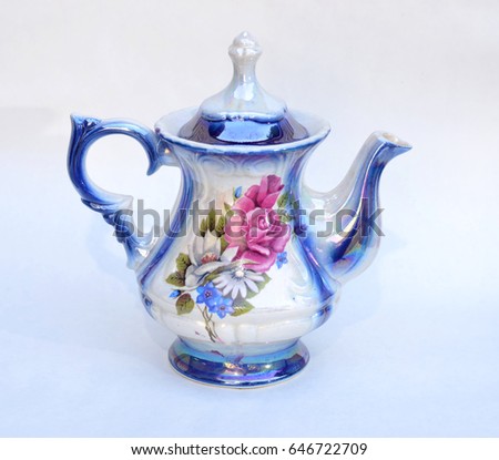 Teapot with a picture of a flower on a white background.