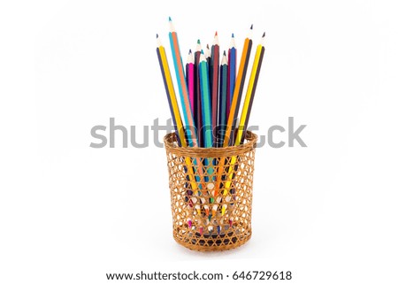 Sharp tips of colored pencils sharpen from sections of a wicker tube, on a white background