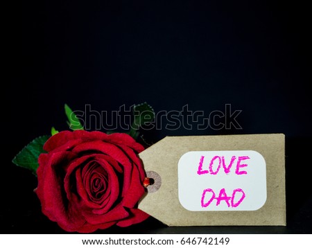 Father's day concept. LOVE DAD message with red rose on black background