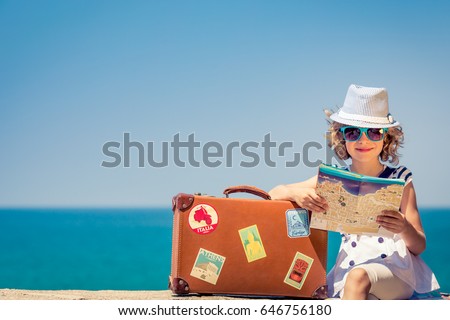 Happy child with vintage suitcase and city map. Kid having fun on summer vacation. Travel and adventure concept Royalty-Free Stock Photo #646756180