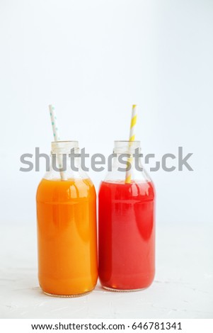 Strawberry and orange juice. The glass bottle. White background. The concept of beverages, health food and vegetarian