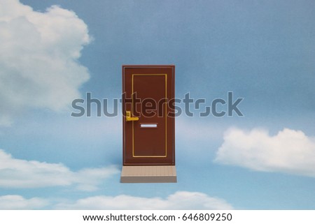Door to new world.
Close door on blue sunny sky with fluffy clouds. 
Concepts like new life, success, future perspective, hope, religion.