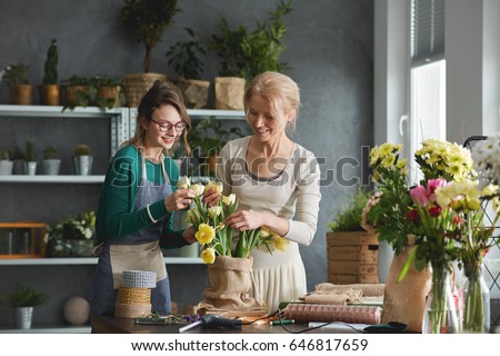 Creative florists preparing tulip bouquet in sack Royalty-Free Stock Photo #646817659