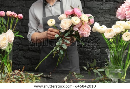 Male florist creating beautiful bouquet in flower shop, close up Royalty-Free Stock Photo #646842010