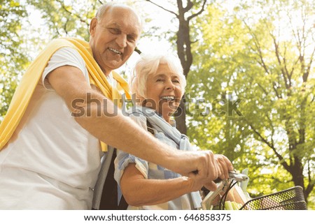 Happy older married couple on a bicycle trip on summer day