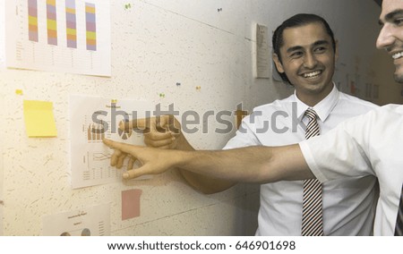 Young both business man pointing and looking to his side with a smile on his face,Data and document background,Businessman pointing at business concept,Age 20-30 years